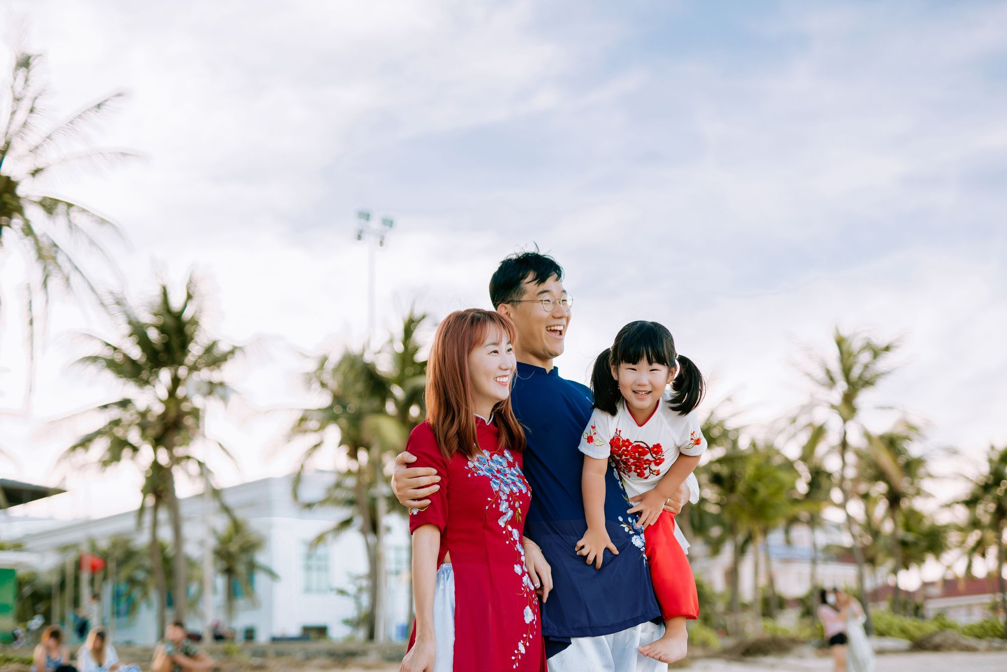 A happy family with their young daughter by the beach