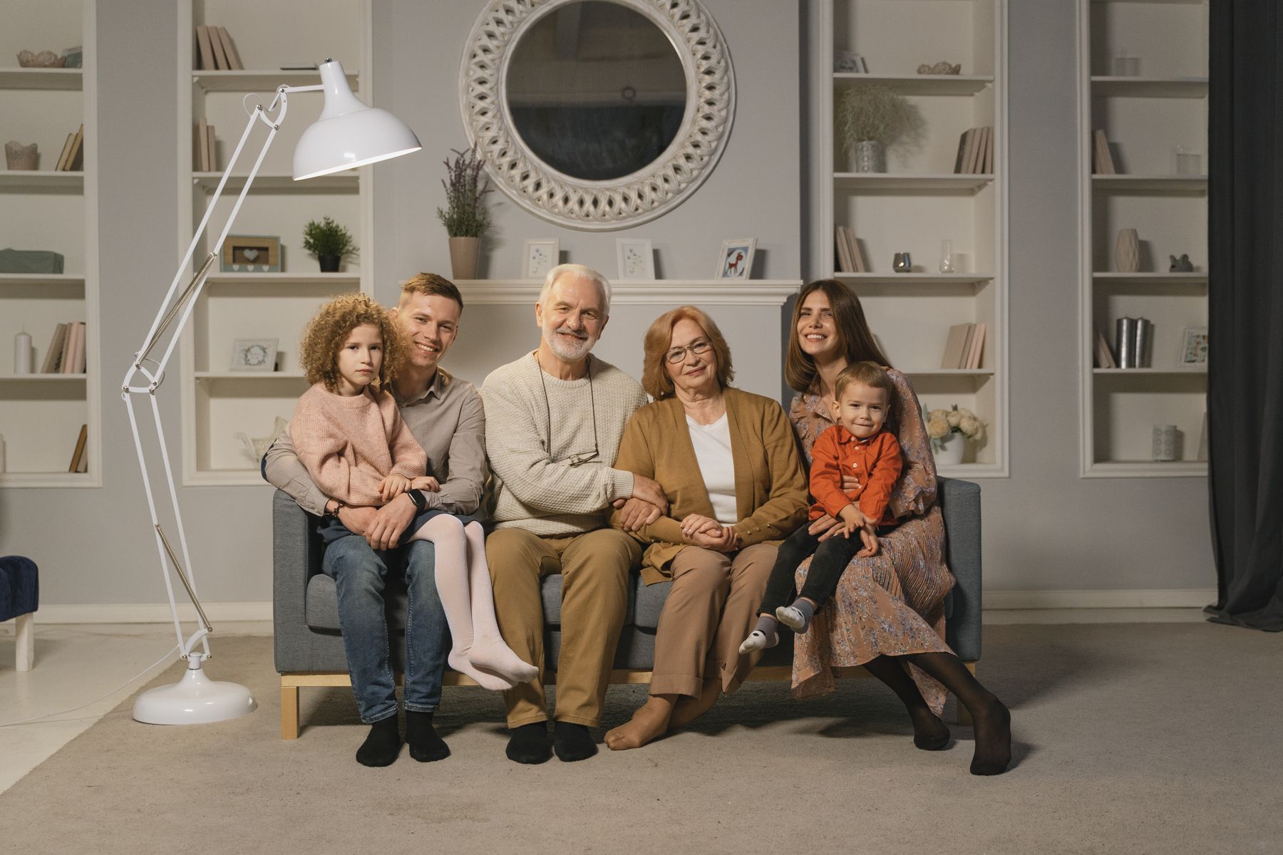 Three generations of a family sitting together on a sofa at home